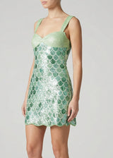 Green sequin dress worn by a model on a light gray background