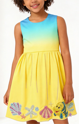 Child wearing a colorful dress with shell designs on a white background