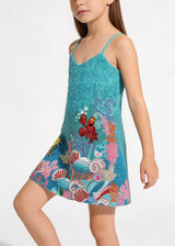 Child wearing a colorful dress with a cartoon character on a white background