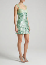 Green sequin dress worn by a model on a white background