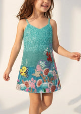 Child wearing a colorful dress with an underwater theme on a white background