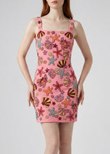 Pink dress with colorful sea-themed pattern worn by a model on a plain background