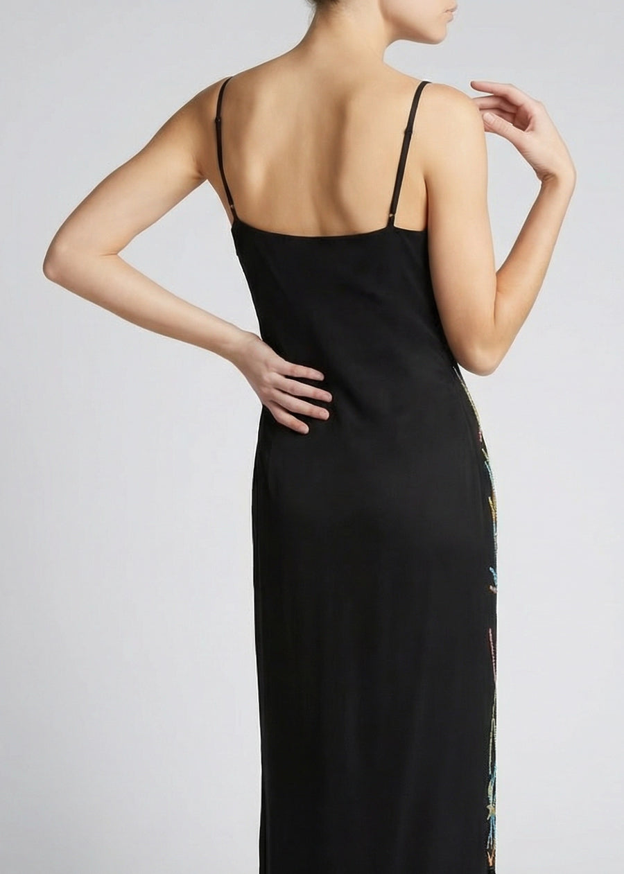 Black slip dress with thin straps on a plain background