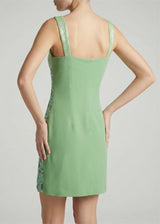 Green dress with lace details on a plain background