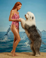 Woman in pink swimsuit with a large dog on a beach with dolphins in the background