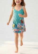Child wearing a colorful dress with an underwater design on a white background