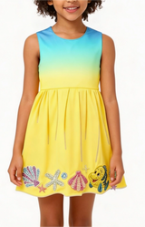 Child wearing a colorful dress with sea-themed designs on a white background
