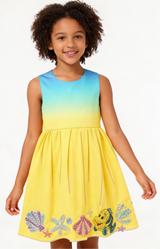 Young girl wearing a colorful dress with shell designs on a white background