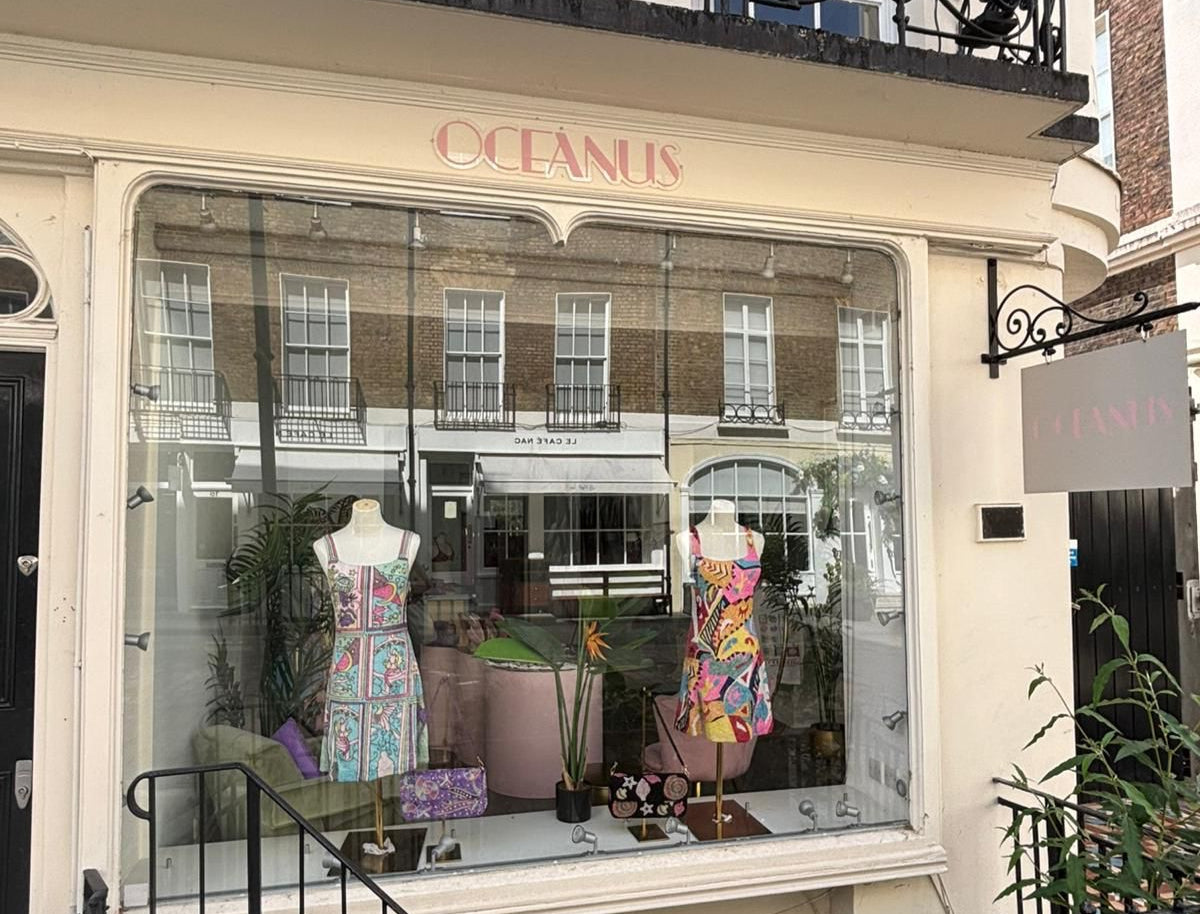Storefront with 'Oceanus' sign and mannequins in a window display.